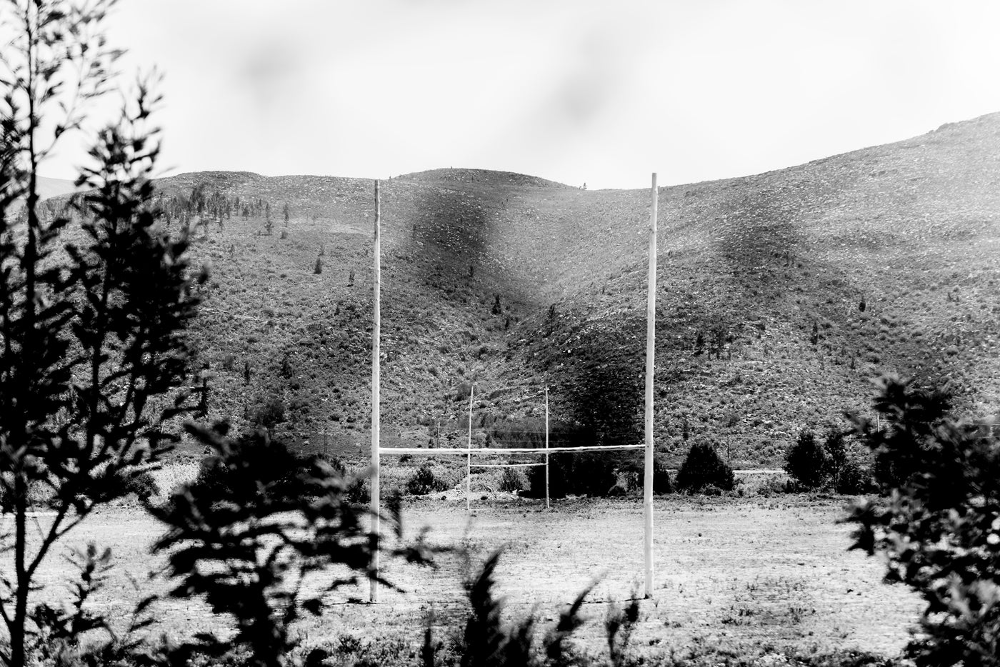 Black and white photo of a field with hills in the background
