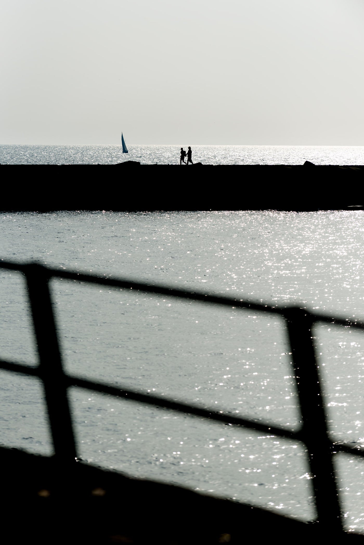 A couple walk along the harbour wall at Scheveningen.