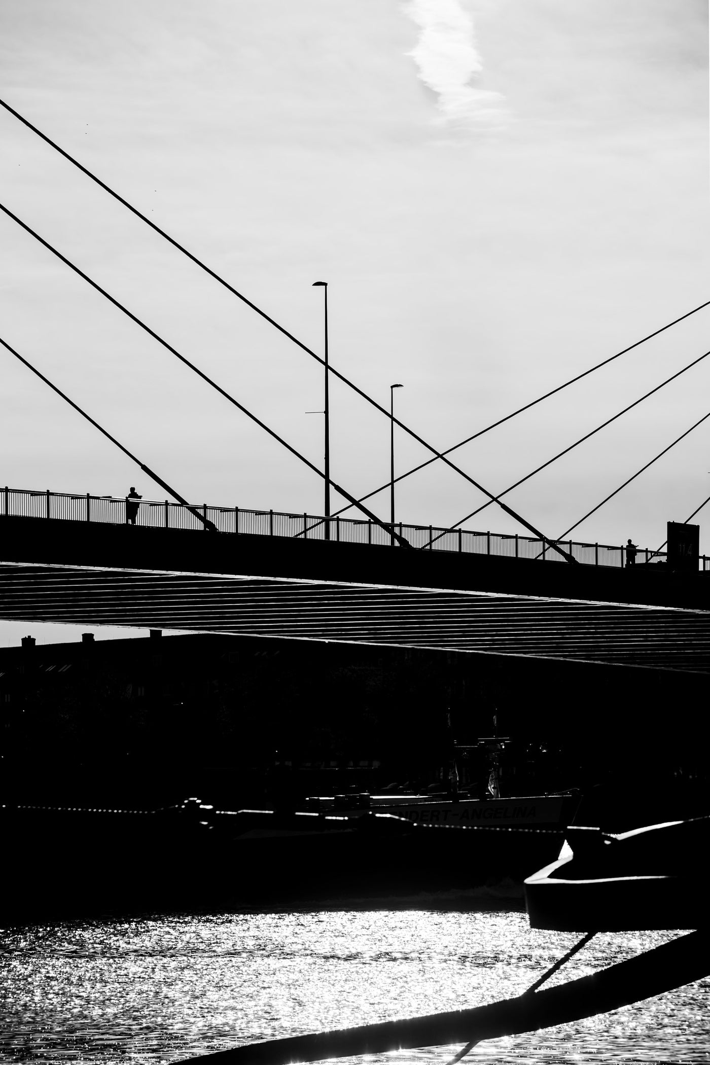 Black and white photograph of two people standing on the Willemsbrug in Rotterdam.