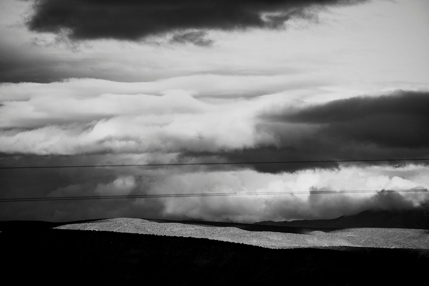 A black and white detail of layered clouds and shadows fallen on the land, shot in The Little Kroo.