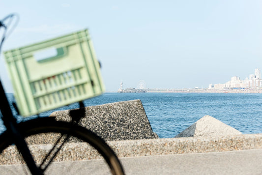 A cyclist in the foreground on the harbour wall with The Pier at Scheveningen in the background.