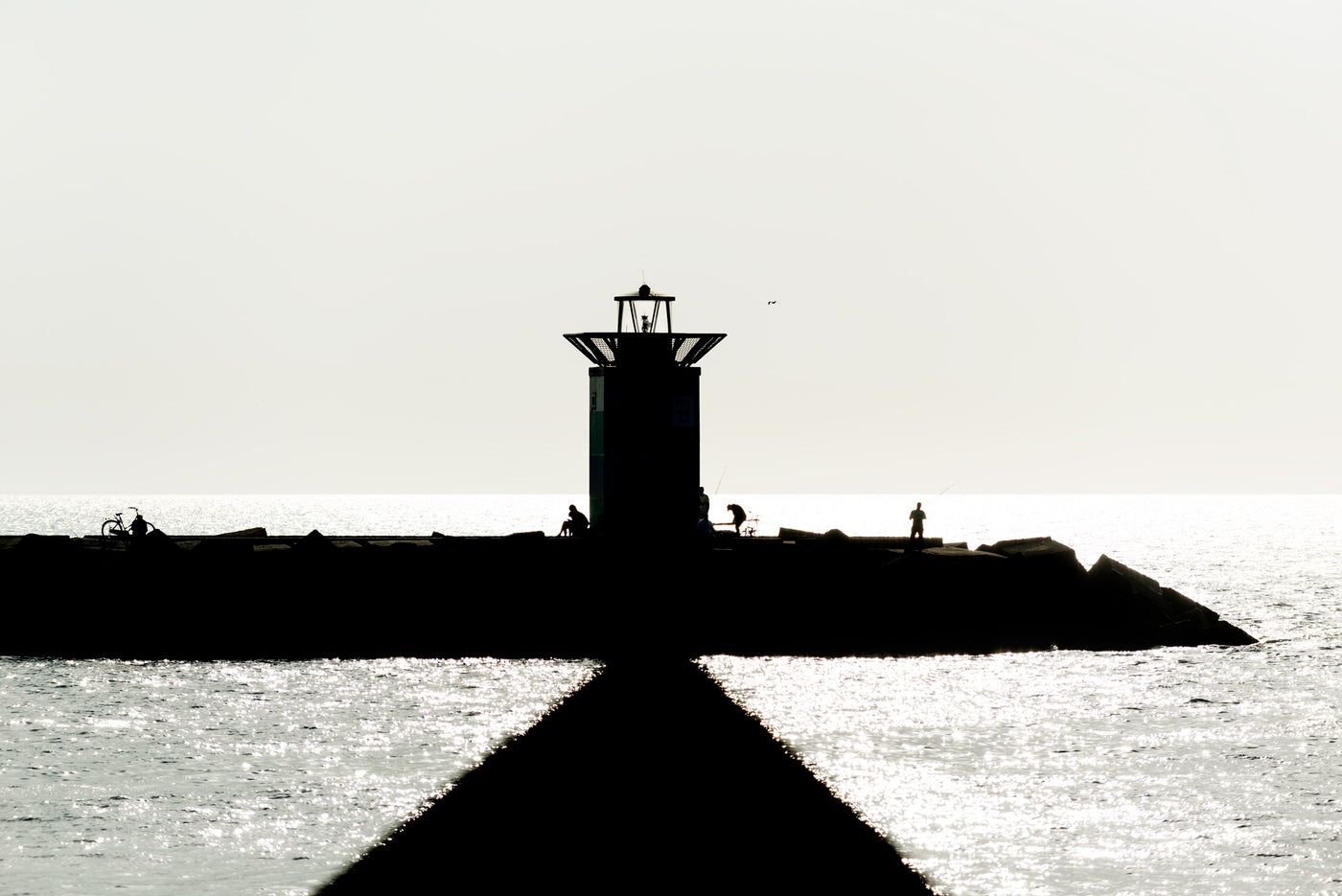 The lighthouse at Scheveningen Harbour depicted agains a bright sky.