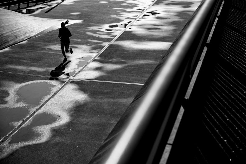 A woman runs through a city landscape in Rotterdam.