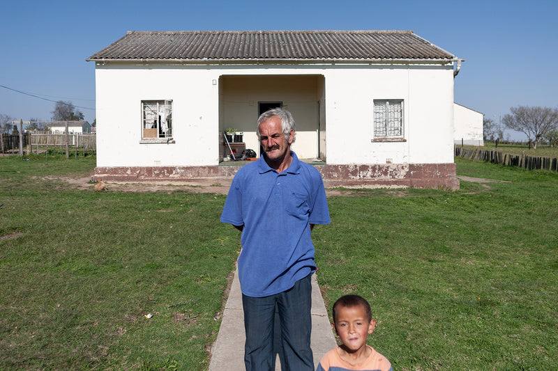 A man and child in front of their house in Karatara.