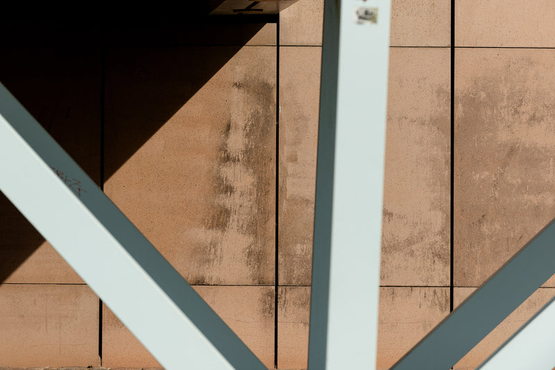 Light and shadow study under a bridge in an urban environment.