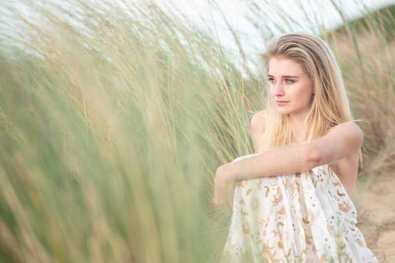 Model photograph shot in the grass near the shoreline.