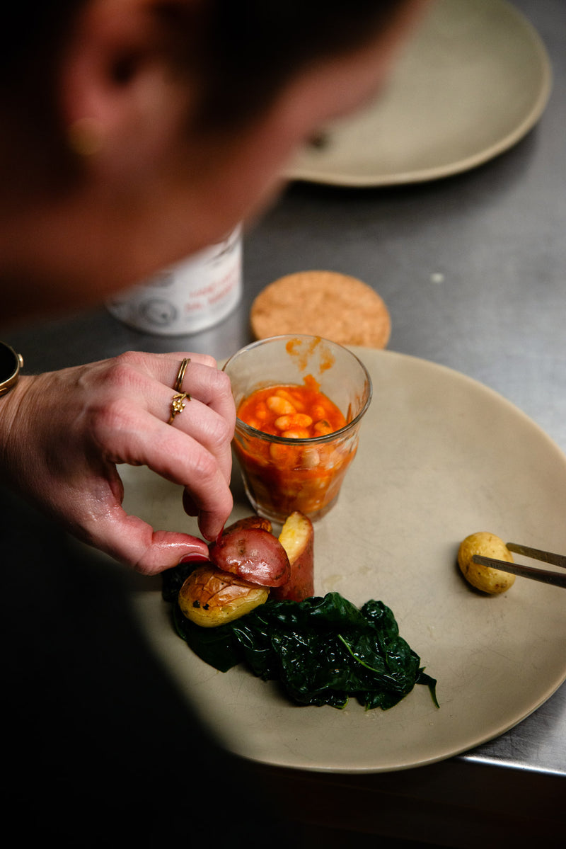 A chef finishes a plate in a restaurant kitchen.