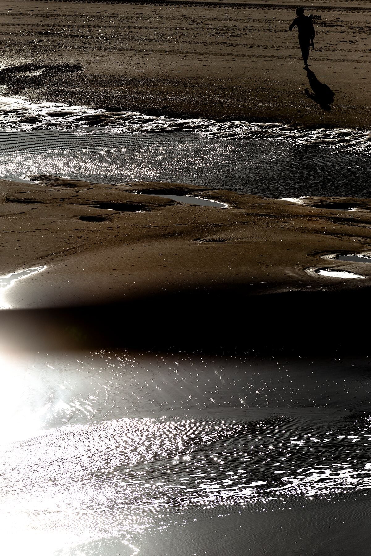 A surfer in the light and shadow at Scheveningen