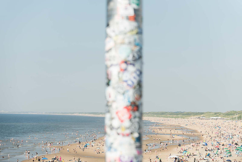 Looking past a light pole onto the crowded Scheveningen beach pier.