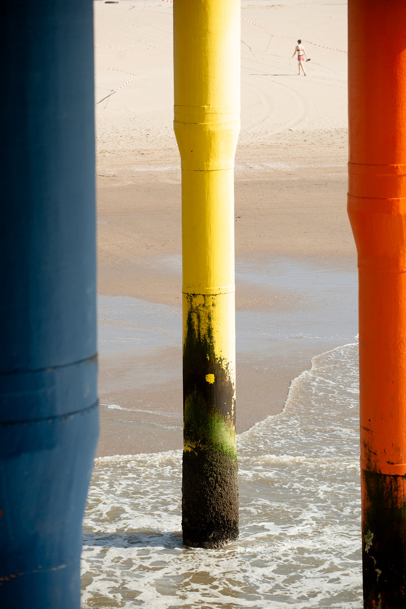 Three legs of the a pier in the sea.