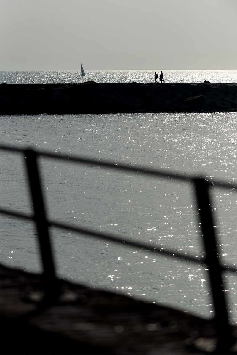 People walk on the Harbour wall at The Hague.